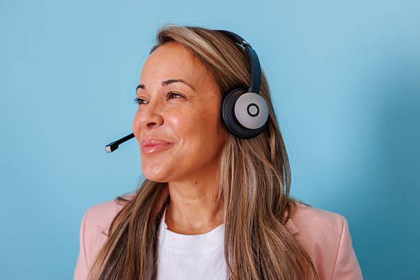 istock Happy call center agent communicating with customers, offering professional help and technical assistance on a blue background 2253320078