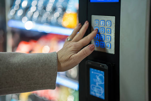 istock Woman using keypad on vending machine for snack purchase 2253320084