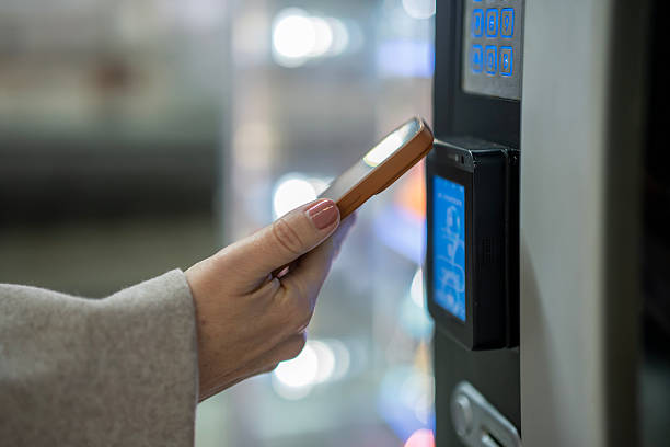 istock Woman paying for vending machine item with mobile phone 2253320096