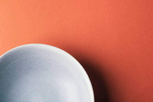 istock Minimal abstract scene with matte ceramic plate on warm orange background, closeup. Top view 2253322060