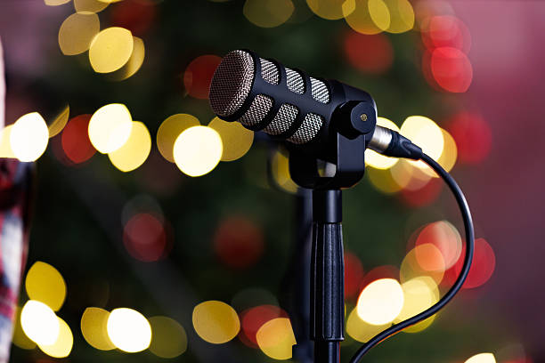 istock Studio microphone with festive bokeh lights background. Professional studio microphone against blurred festive lights, ideal for podcasting, holiday broadcasts, streaming, and seasonal audio production concepts. 2253322154