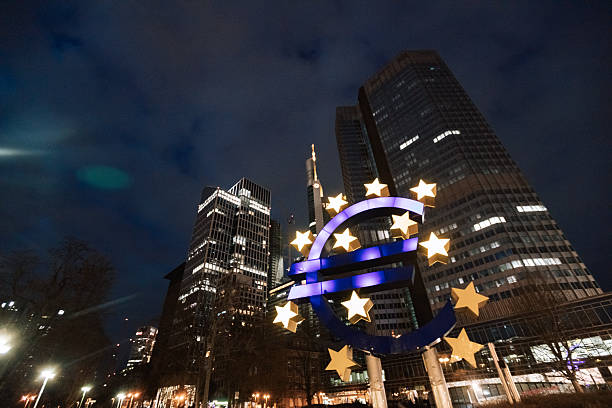 Frankfurt am Main, Germany – February 17, 2024: Illuminated euro symbol with modern skyline in the background at night near the ECB.