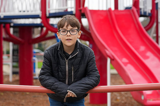 istock Little boy posing looking at the camera with a playground in the background 2253328831