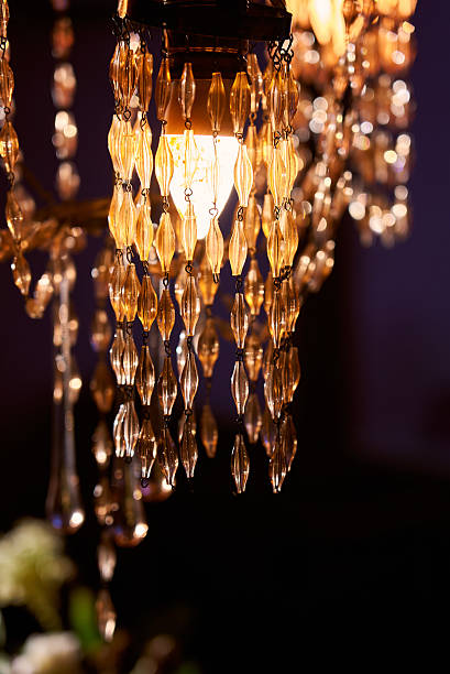 istock Beautiful chandelier with crystals hanging in dim light setting 2253334702