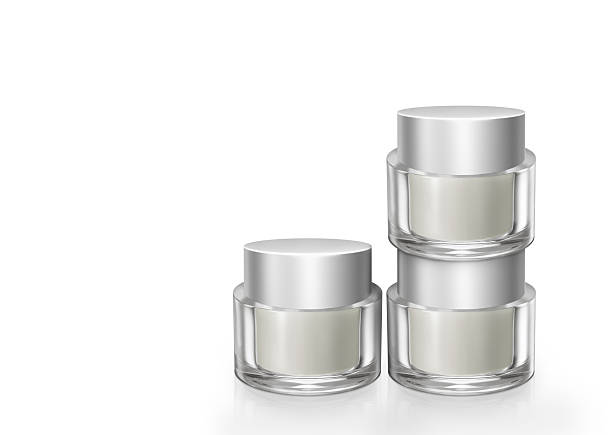 Jars of skin cream and cosmetics are placed on a white surface.