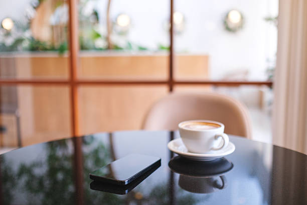 istock A mobile phone and a coffee cup on the table in cafe 2253342616