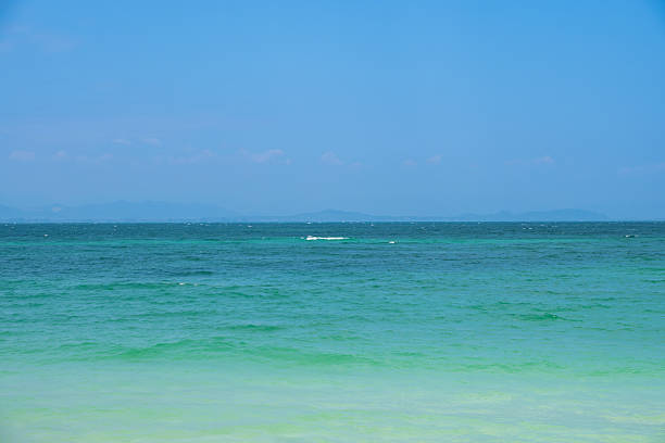 Crystal-clear turquoise waves meet a tranquil horizon under a radiant sky—perfect for travel ads, screensavers, or nature backgrounds. Coastal serenity, ocean escape, tropical paradise.