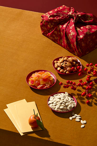 Top-down style Chinese New Year scene with traditional snacks, fruits jam, red gift box and lucky envelopes. Ideal for festive marketing visuals, design product and add text