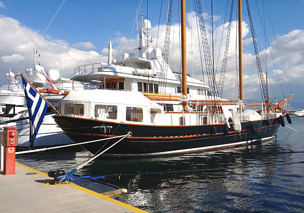 Vintage style tourist boat docked at Zea Marina (Pasalimani) in Piraeus, Greece. The vessel features classic design elements with wooden masts and metal structure, blending old-world charm with a modern marina setting.