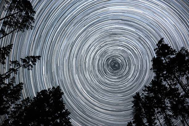 istock Night sky showcasing star trails over a forest clearing in bright starry sky 2253347778