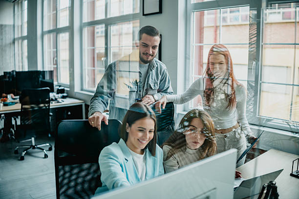 istock Engaged coworkers collaborate on a project in a bright office space with large windows during working hours 2253348147