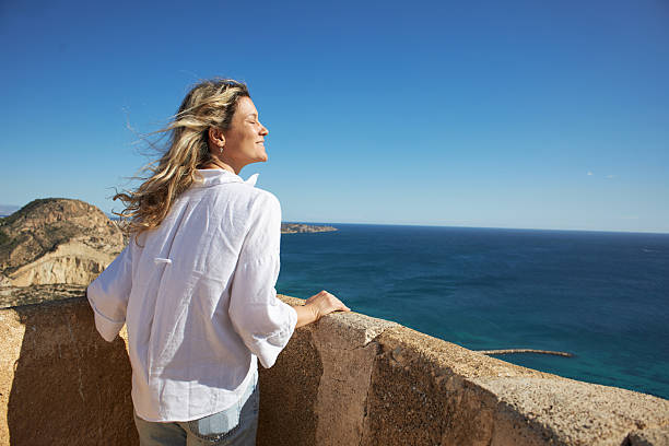 Happy woman taking a moment to breathe and relax while enjoying the beautiful sea view