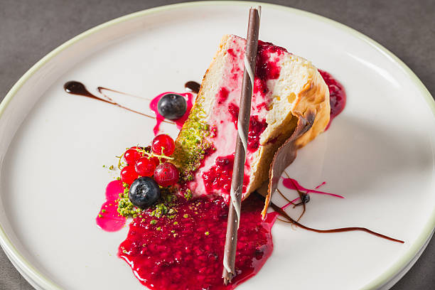 istock Cheesecake slice topped with fresh berries and vibrant sauce 2253349480