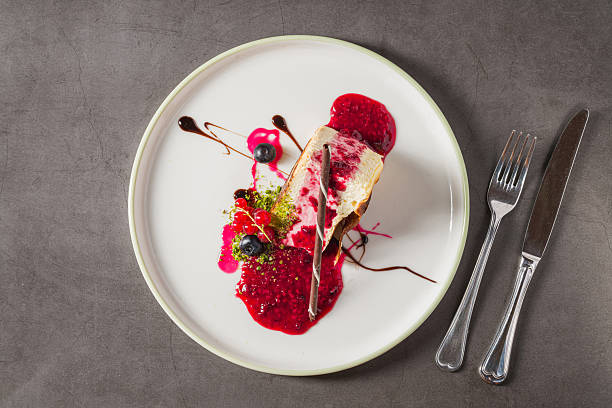 istock Cheesecake slice topped with fresh berries and vibrant sauce 2253349490