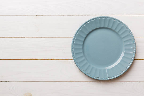 Top view of empty grey plate on wooden background. Empty space for your design.
