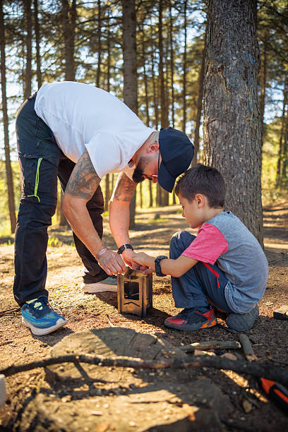 istock Father And Son Campout Bonding As They Build A Lantern In The Forest 2253352989
