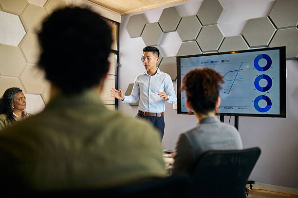 istock Asian Businessman Presenting Data to Diverse Team in Office Meeting 2253353806