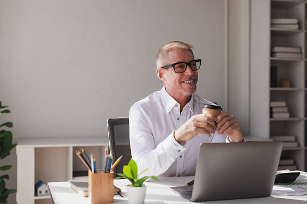 istock Happy senior businessman working online drinking coffee 2253355267