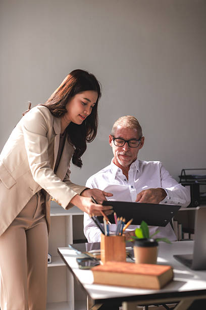 istock Businesswoman assisting senior manager with paperwork 2253355287