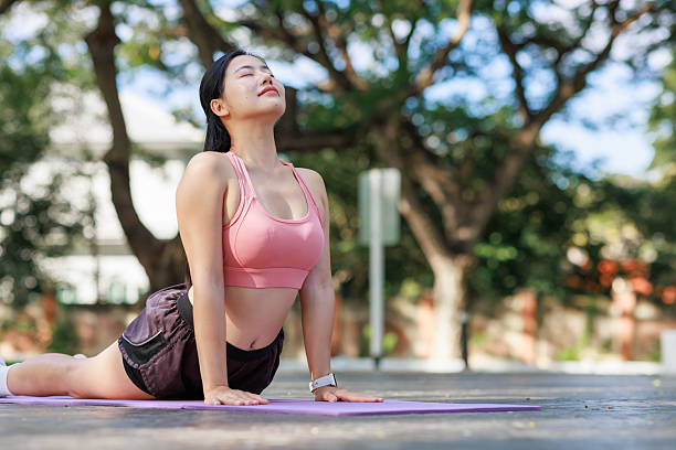 istock Young woman practicing stretching yoga cobra pose outdoors 2253356826