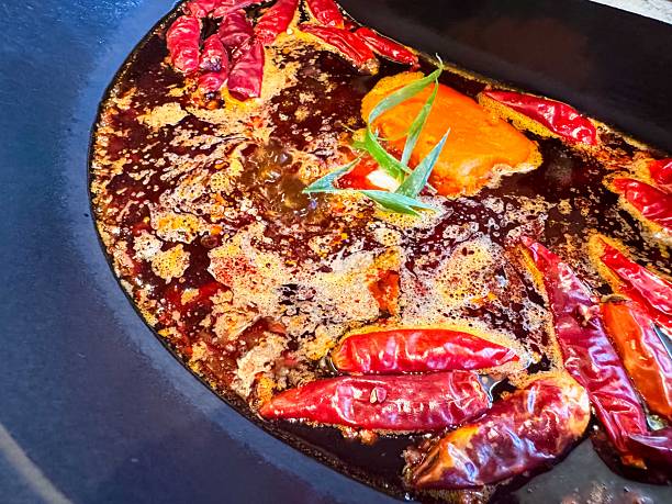 istock Authentic Chengdu-style hot pot with spicy chili broth, assorted meats, vegetables, and dipping sauces. 2253356973