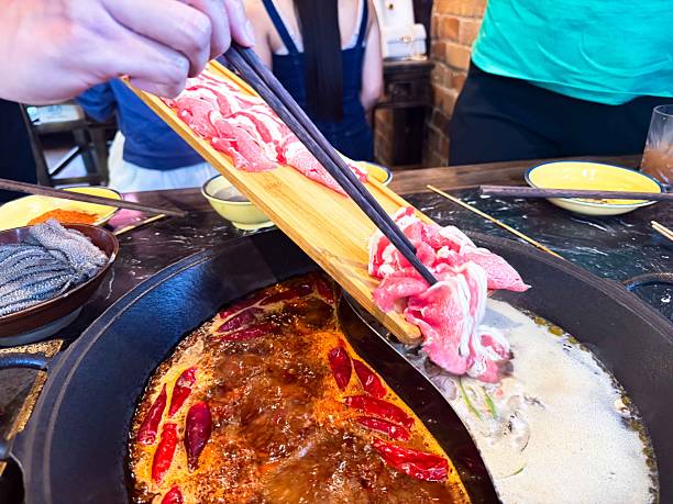 istock Authentic Chengdu-style hot pot with spicy chili broth, assorted meats, vegetables, and dipping sauces. 2253356997