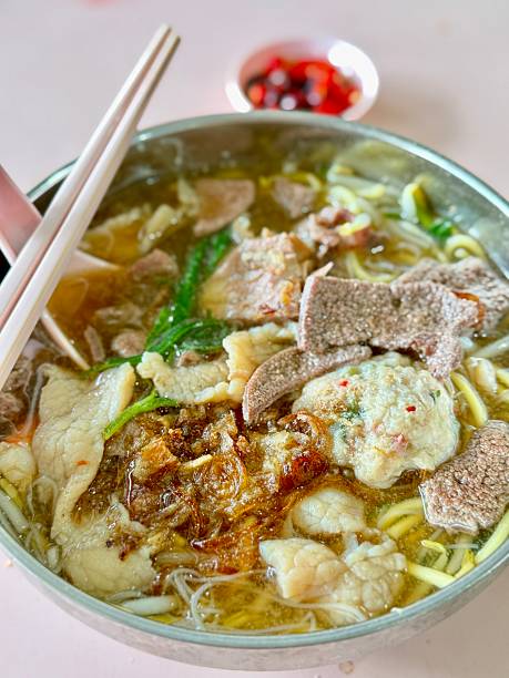 Singapore local flavor yellow noodle soup with shrimps, pork, liver