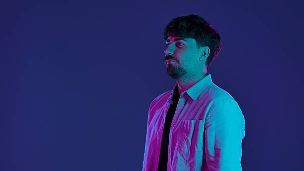 istock Man in Colorful Neon Lighting on Dark Background 2253362551