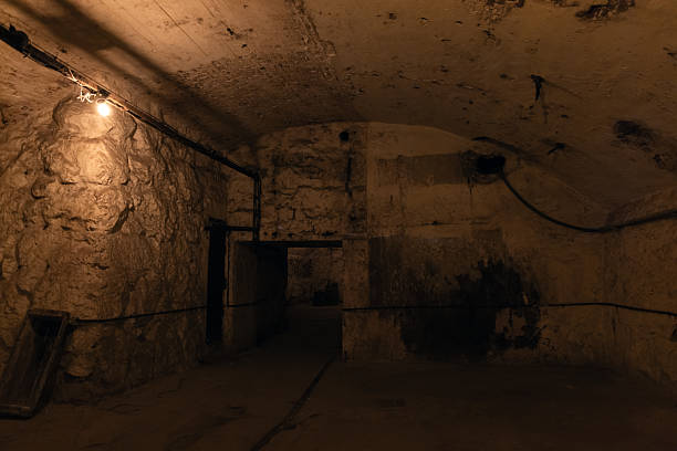 istock A dim underground basement scene with rough stone walls 2253364533
