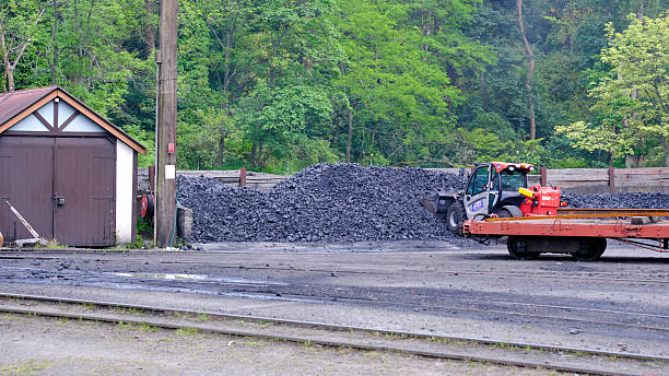 Wheel Bucket Excavator Working At Coal Mines with coal-fired power station in background.