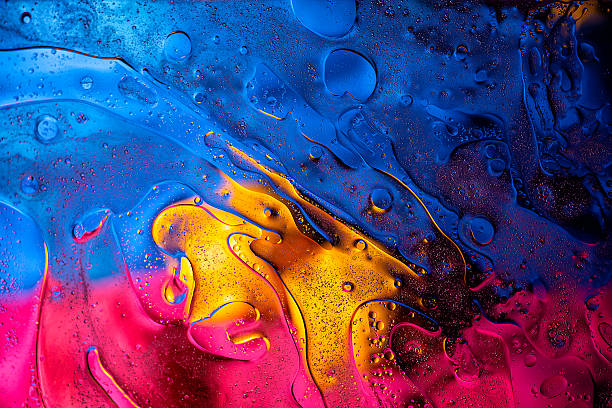 Bright abstract oil and water macro with vivid pink, blue and yellow contrast.
