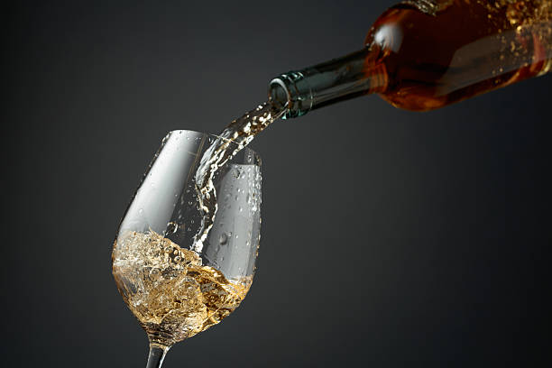 istock Pouring white wine from a bottle into a glass. 2253369324