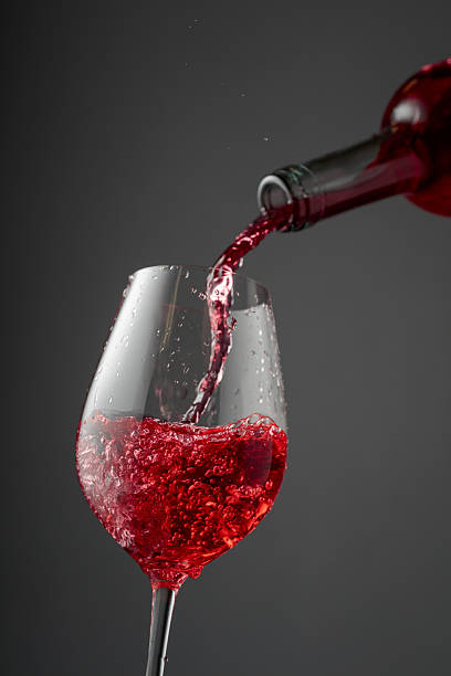 istock Pouring pink wine from a bottle into a glass. 2253369333
