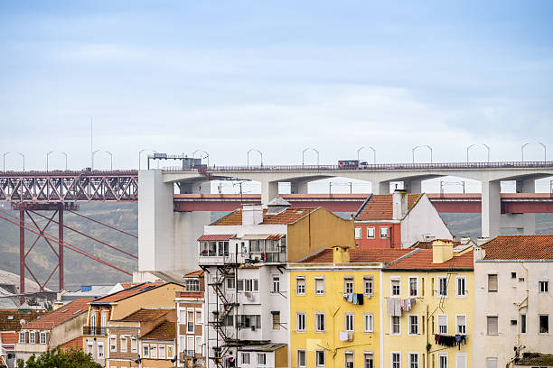 Lisbon Portugal December 06 2025. Apartment buildings in Bairro Alto positioned below a large road bridge forming layered urban infrastructure.