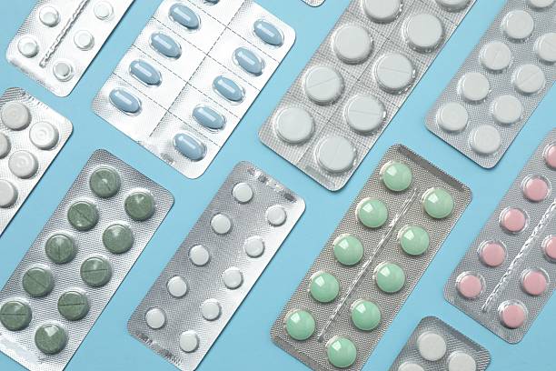istock Pills in blister packs on blue background, close up 2253370290