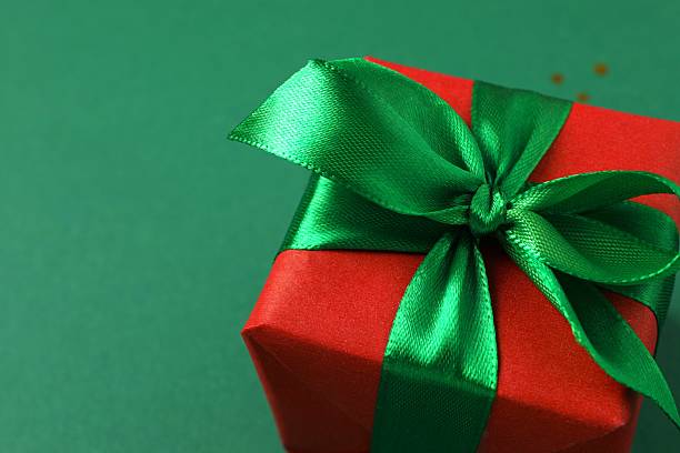 istock Beautiful Christmas gift box tied with bow on color background 2253370622