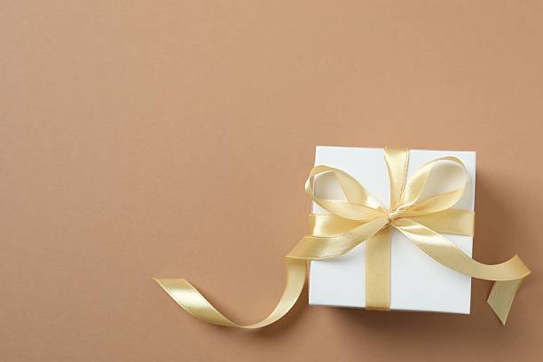 istock Beautiful Christmas gift box tied with bow on color background 2253370637