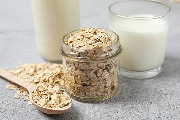 istock Composition with oatmeal flakes on gray background. Cooking breakfast 2253372298
