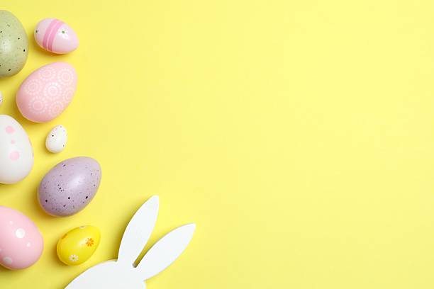 istock Happy Easter. Colorful eggs and bunny ears on color background, space for text or advertising 2253372334