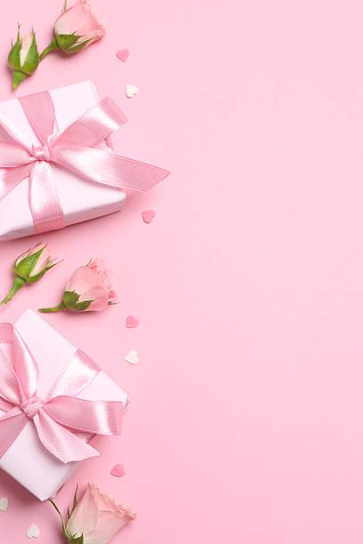 istock Beautiful composition with pink roses and gift boxes on color background 2253372562