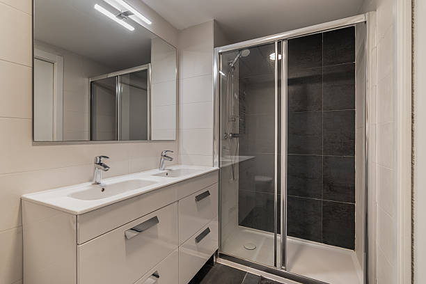istock Modern bathroom with a sleek design. Features a glass shower, double sink vanity, and large mirrors. Neutral color palette with clean lines. 2253372891