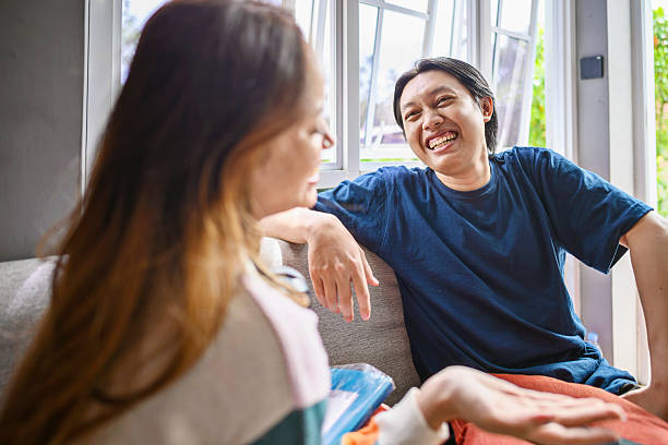 istock Indonesian southeast asian couple enjoying a relaxed conversation at home. Smiling while looking at each other, creating a warm and intimate atmosphere, connection, and leisure 2253373000