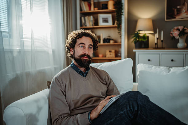 istock Man relaxing on sofa, contemplating life at home 2253373739