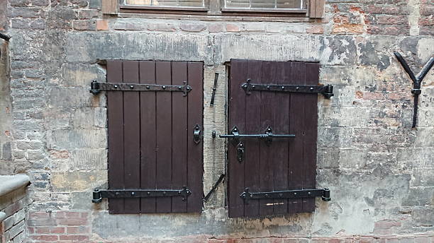 Gdansk, Poland. June 07, 2019. Close up view of historic wooden window shutters mounted on an old brick building facade in the city center.