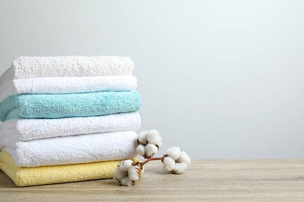 istock Stack of bath towels with cotton flowers on the table 2253374494