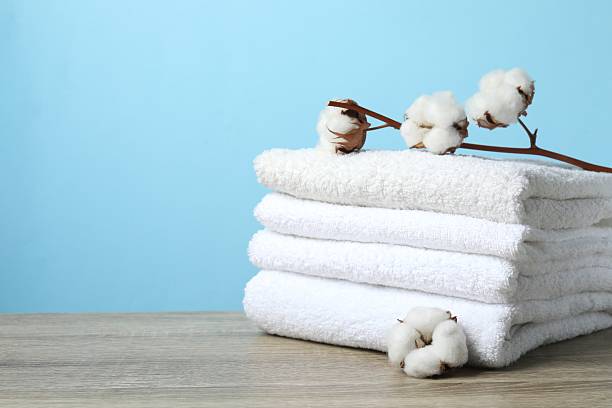 istock Stack of bath towels with cotton flowers on the table 2253374548