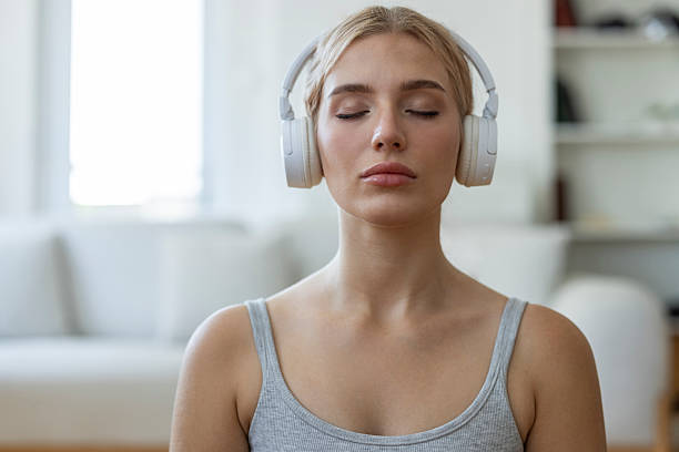 istock Young Woman Practicing Mindfulness Meditation with Headphones Indoors 2253374794