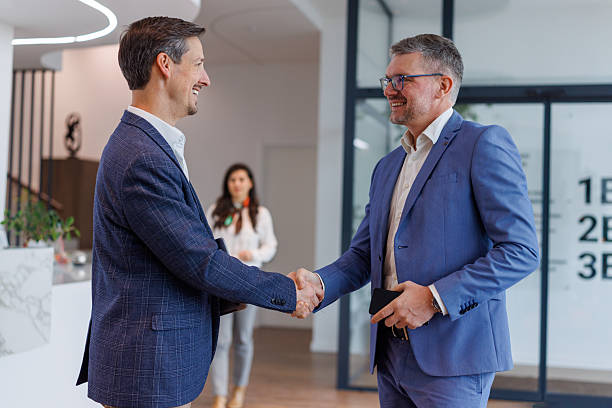 istock Business colleagues shaking hands in modern lobby 2253375600