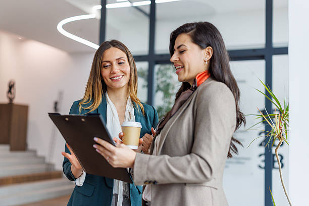 istock Businesswomen discussing project in modern office hallway 2253375654
