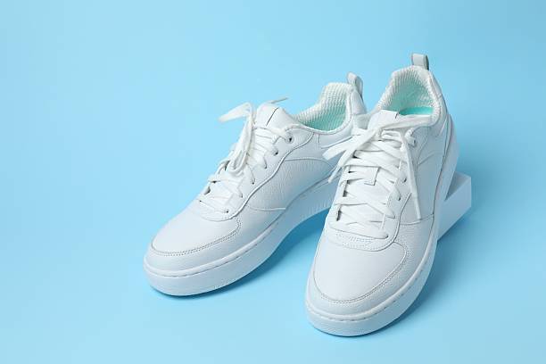 istock White sneakers on a blue background 2253376422